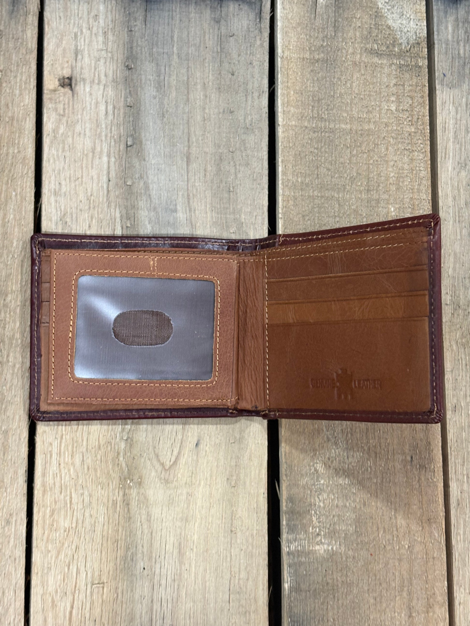 Brown leather wallet with three card slots and one ID window slot on a wooden surface