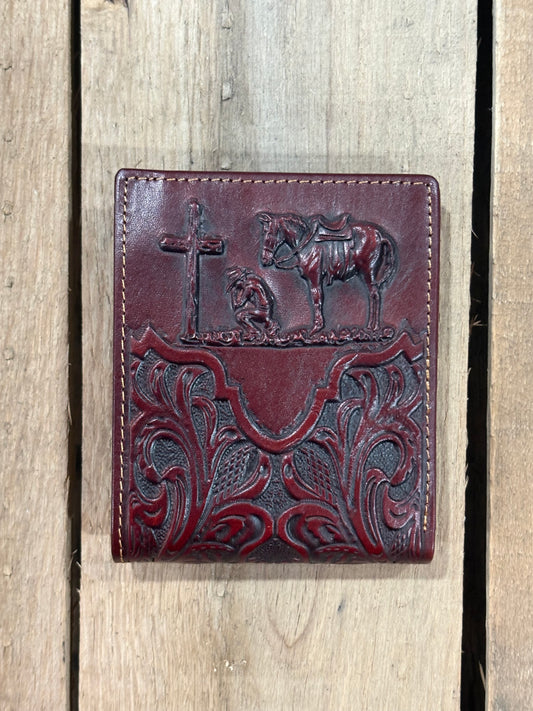 Close up of a Dark Brown leather wallet with embossed designs of a cross, horse, and cowboy on a wooden background