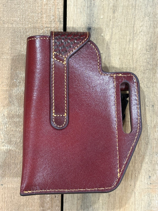 Back view of a brown leather holster with  on a wooden surface