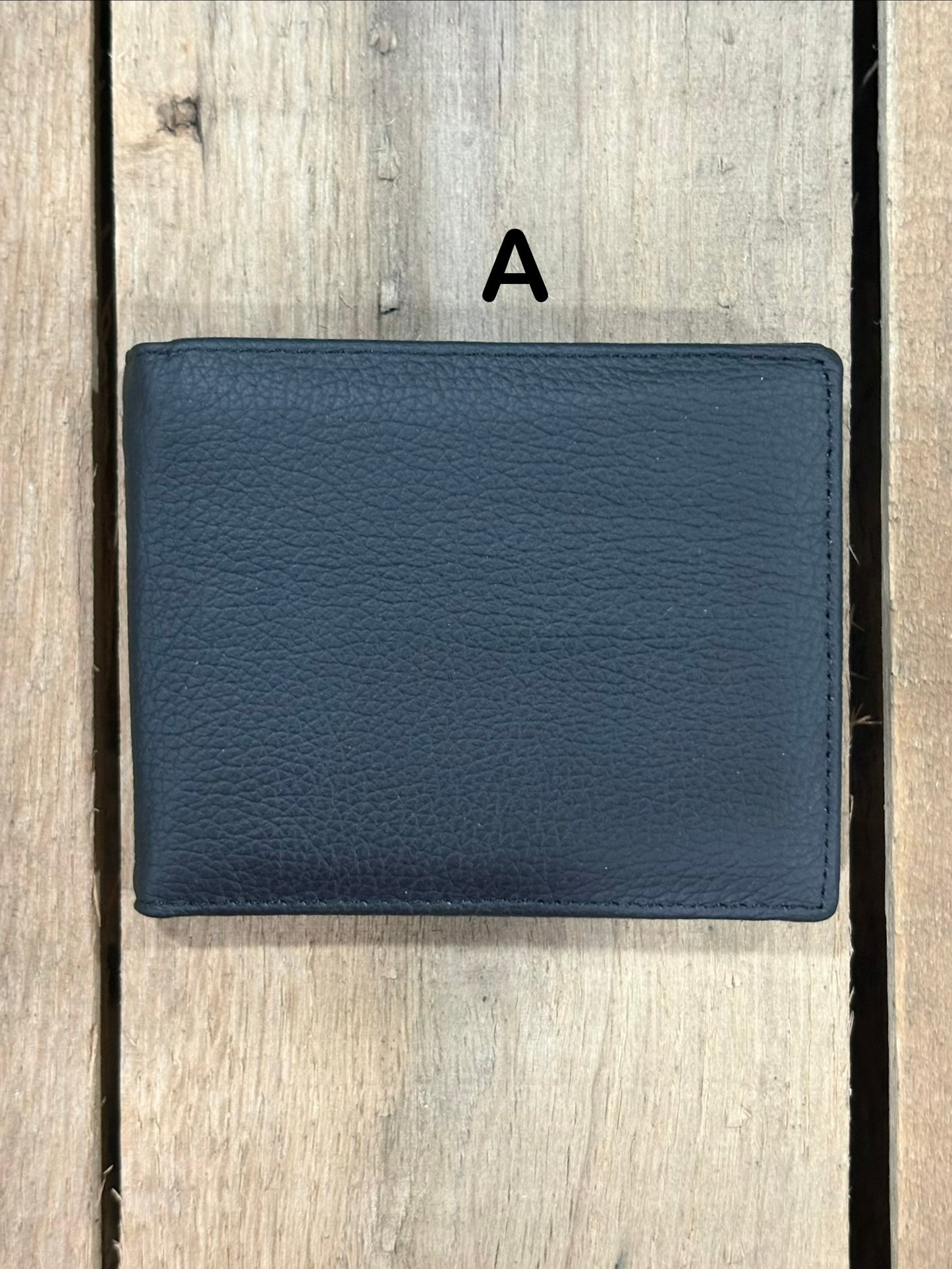 Black smooth leather wallet on a wooden surface