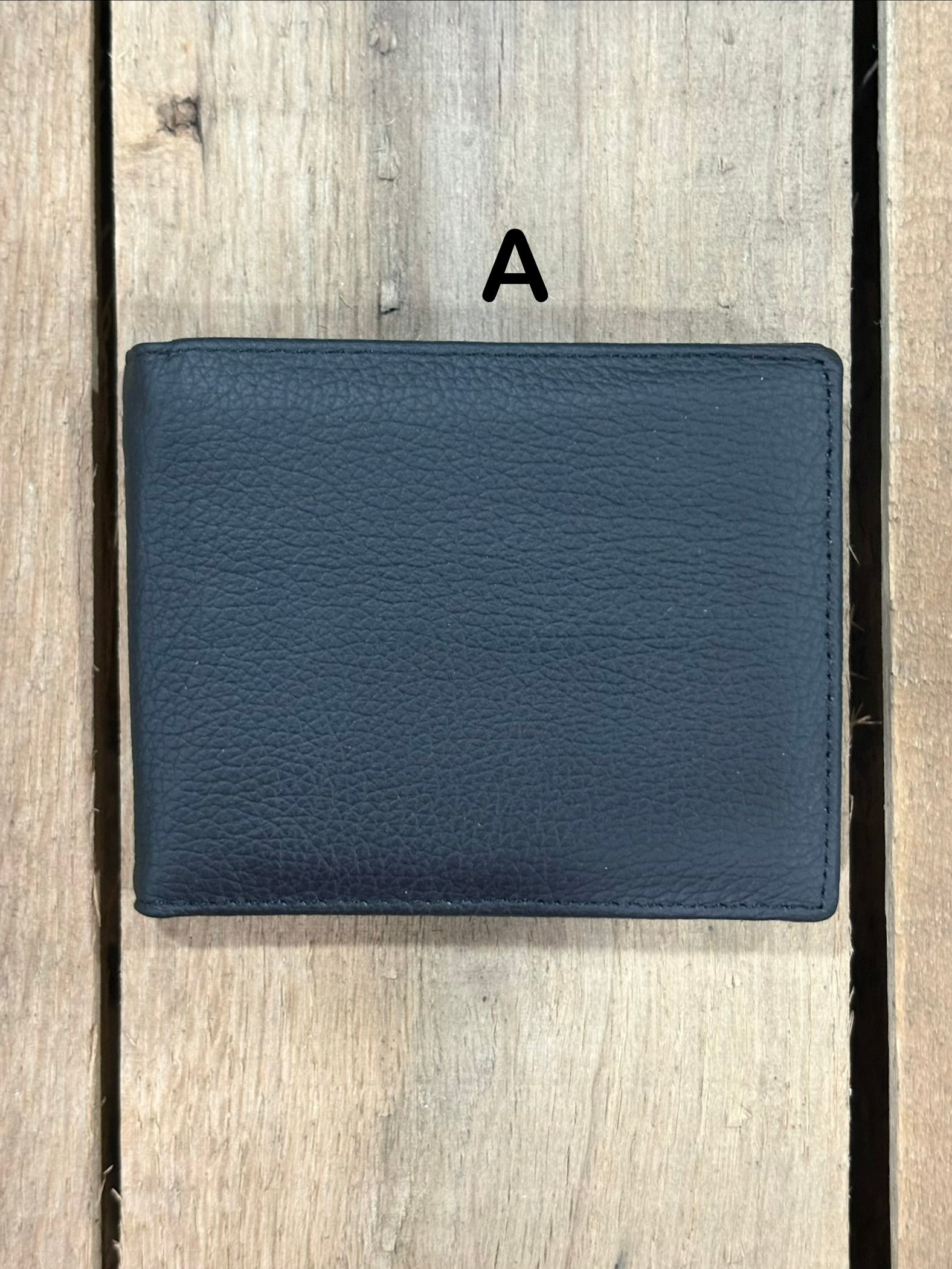 Black smooth leather wallet on a wooden surface