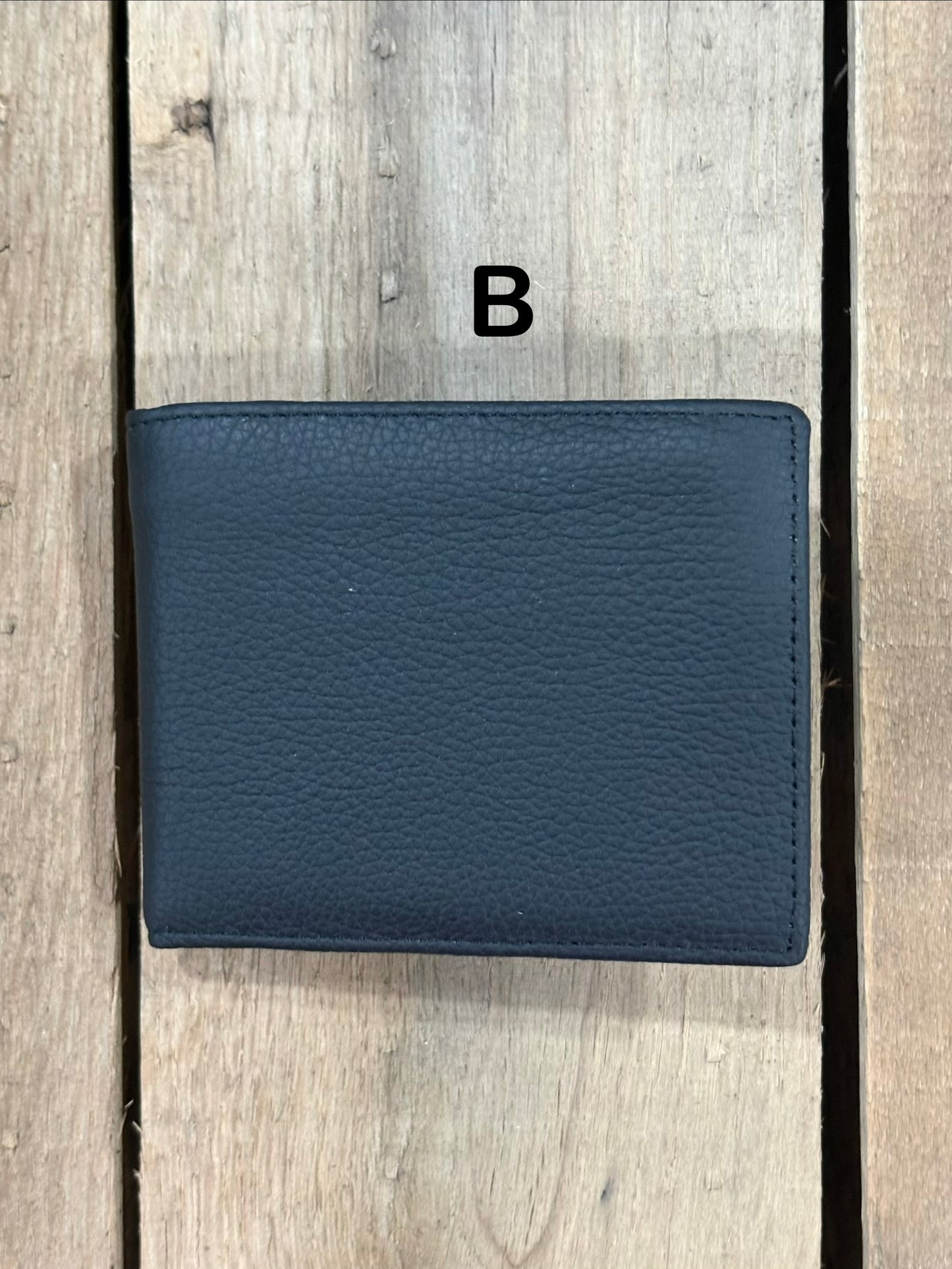 Black smooth leather wallet on a wooden surface