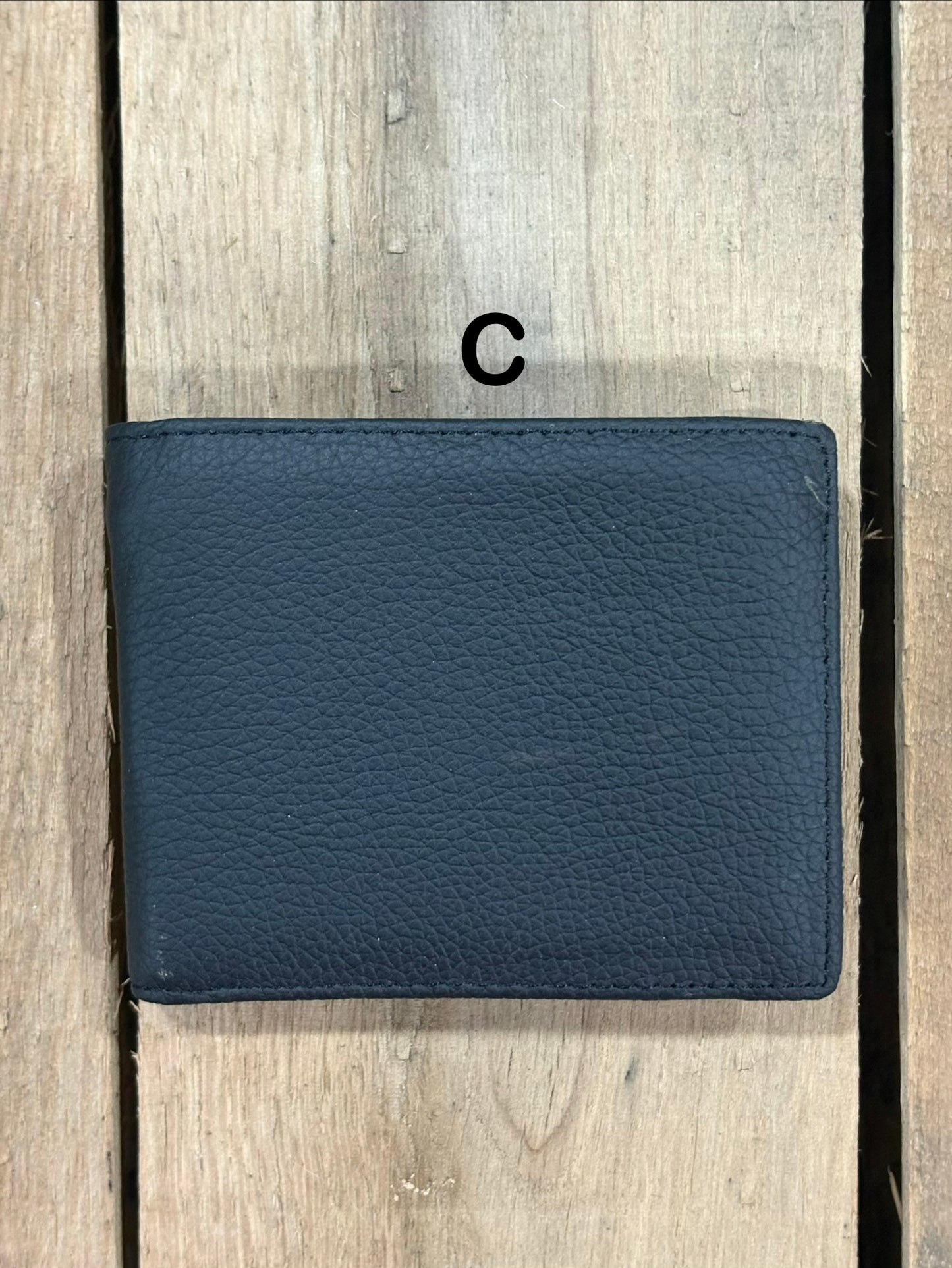 Black smooth leather wallet on a wooden surface