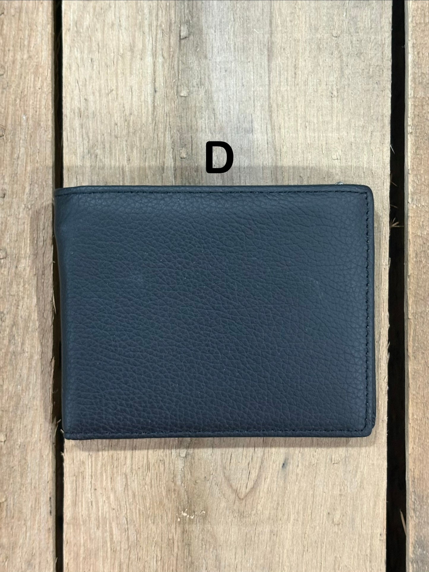 Black smooth leather wallet on a wooden surface