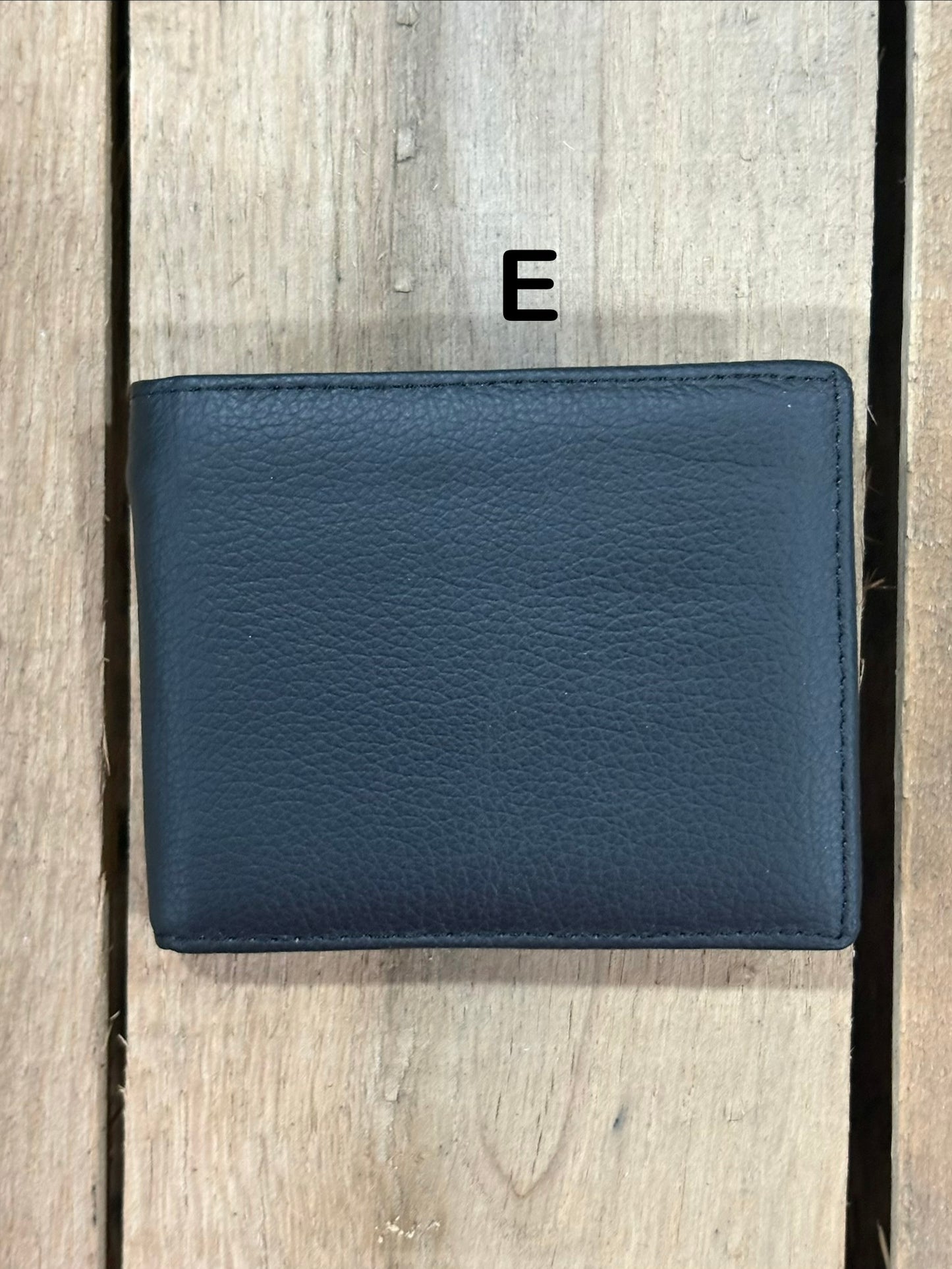 Black smooth leather wallet on a wooden surface