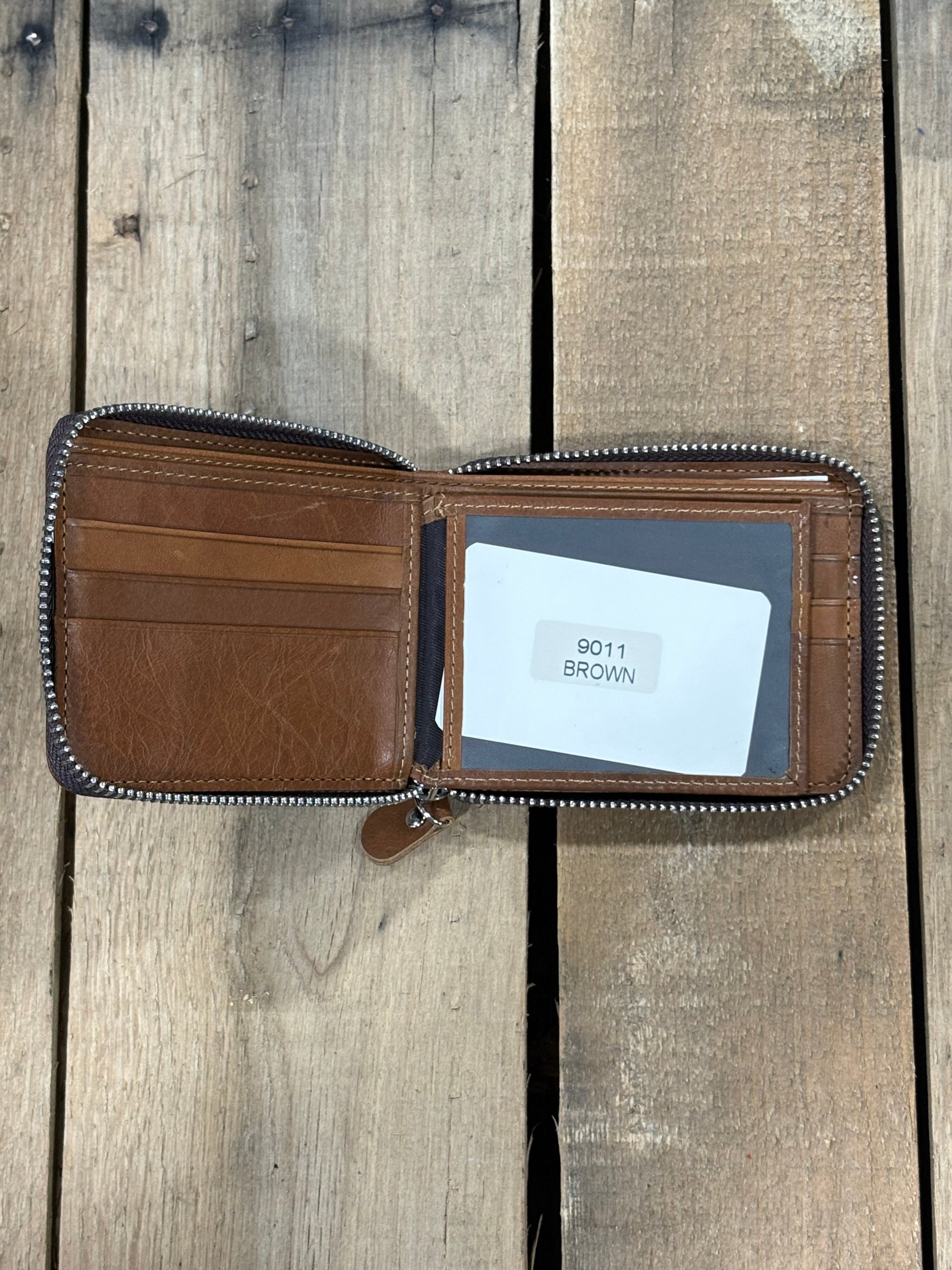 Brown leather wallet with a card inside the ID window slot and three card slots on a wooden surface