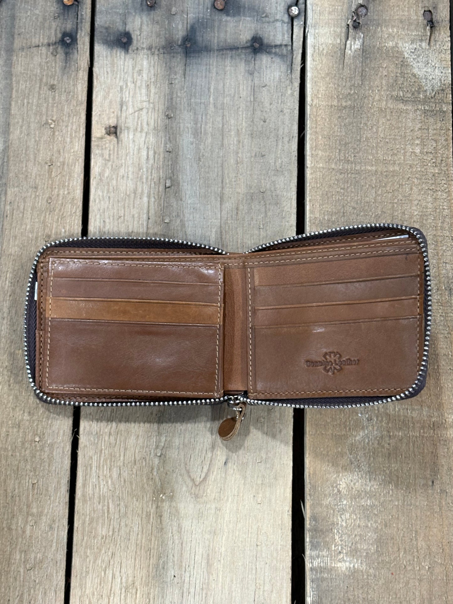 Brown leather wallet with a six card slots on a wooden surface