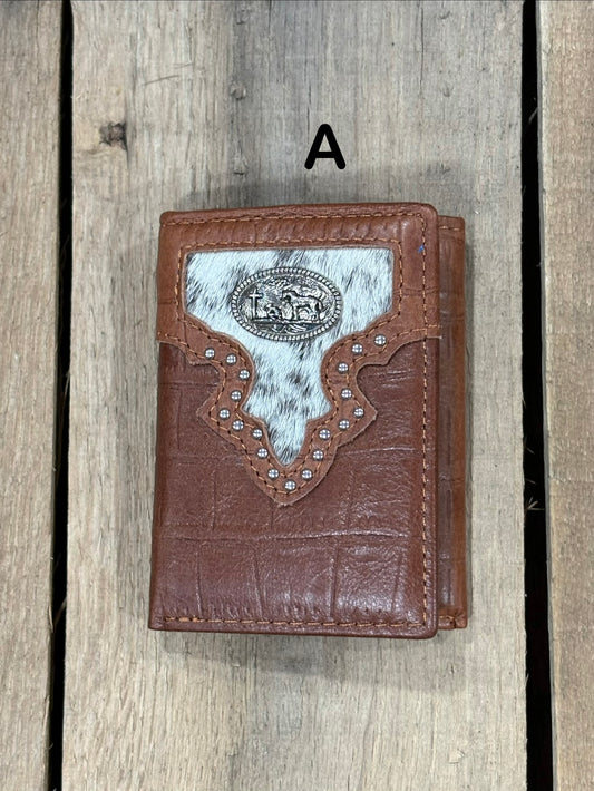 Brown leather alligator print wallet with black and white hairon cowhide, praying cowboy concho on a wooden surface