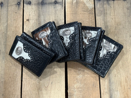 Five black leather wallets with silver Rooster conchos on a wooden surface