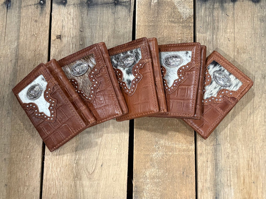 Five brown leather wallets with silver rooster concho designs on a wooden surface