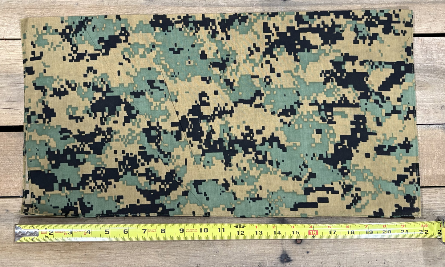 Digital Camo Green bandana with white paisley patterns on a wooden surface, measured by a yellow tape measure.