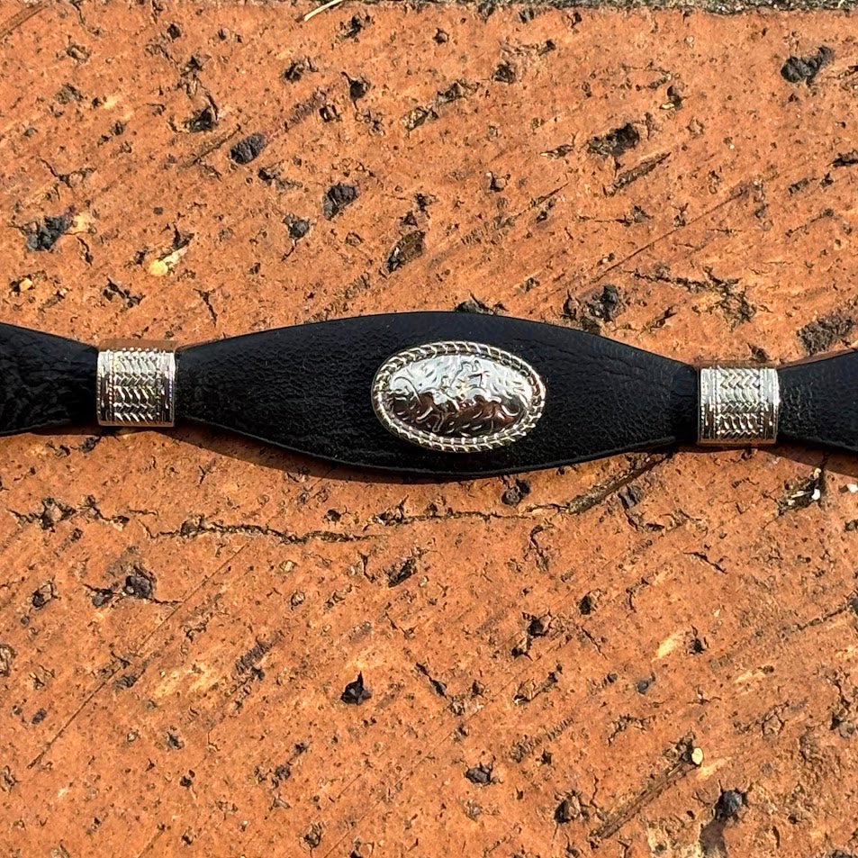 Black leather hat band with a Bull Rider Concho separated by Silver bands. Close up view on Concho.  