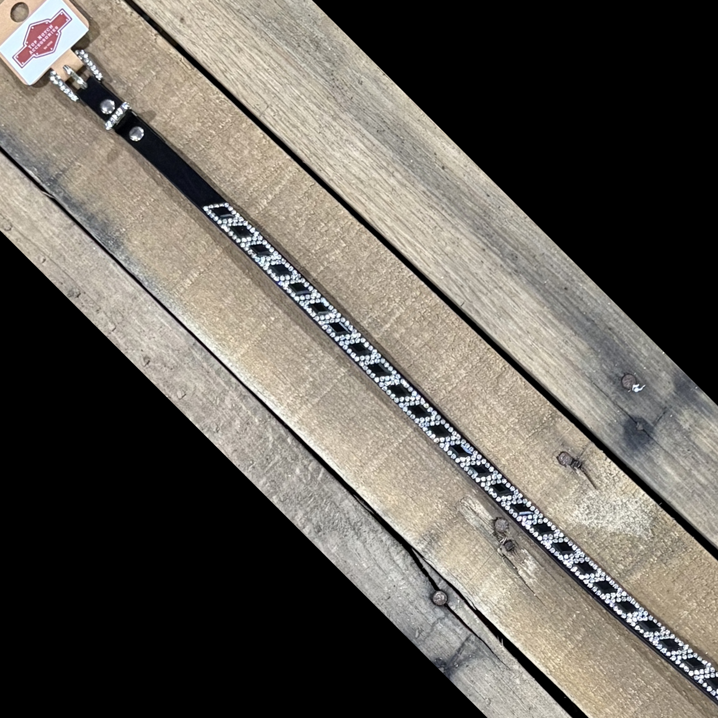 Long black hat band with black diamond sequence on a wooden surface