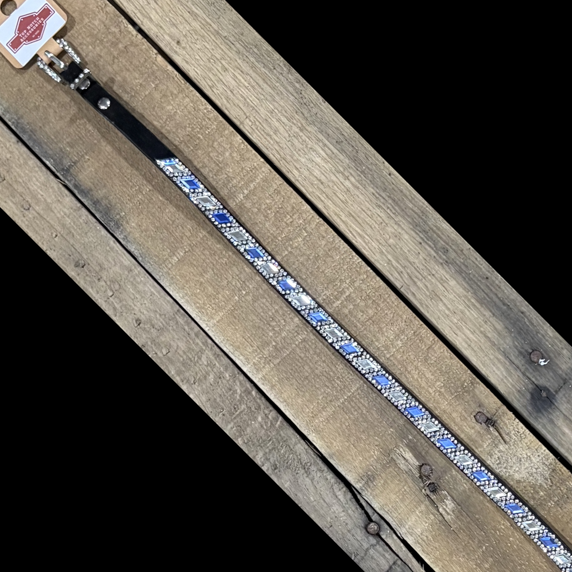 Long black hat band with clear and blue diamond sequence on a wooden surface