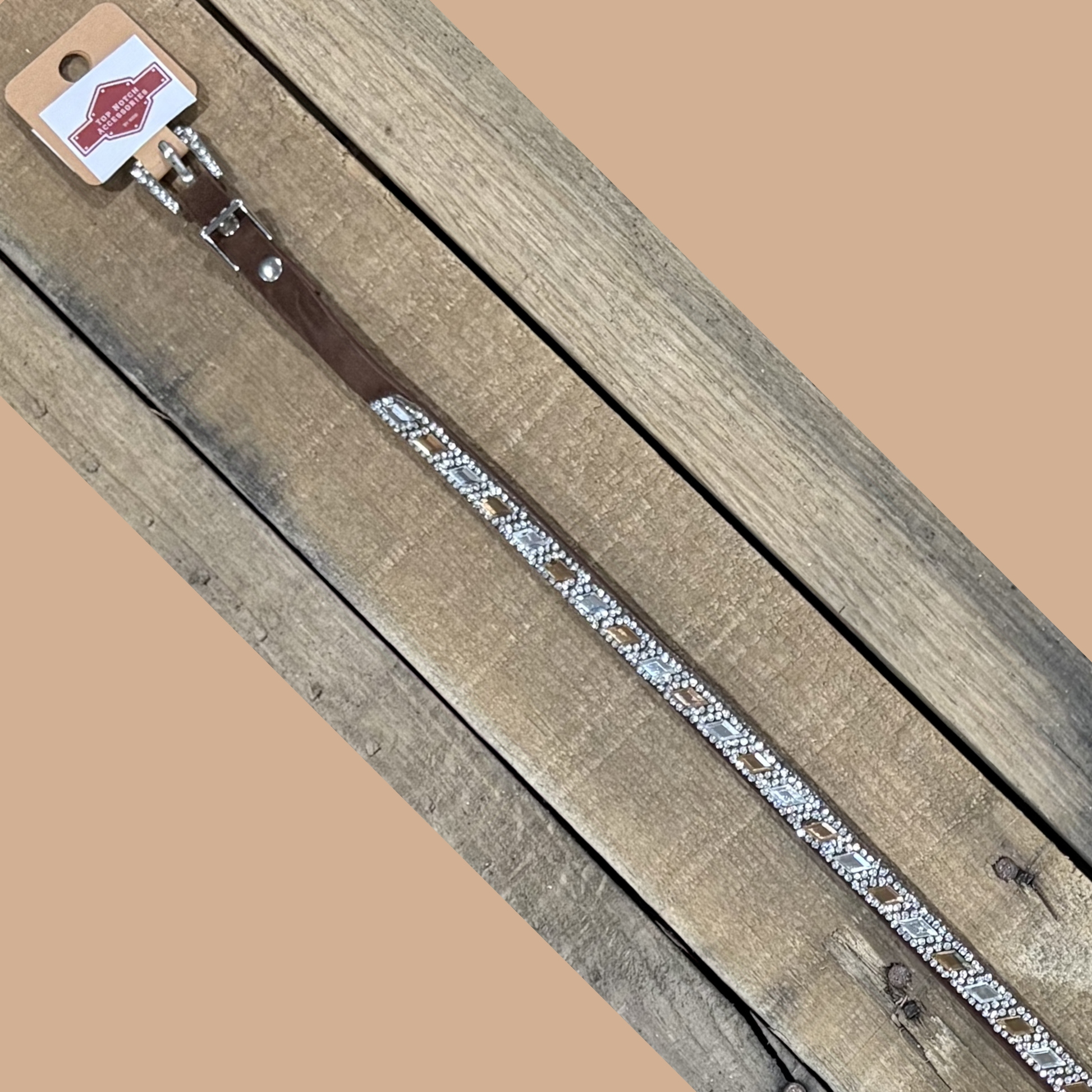 Long coffee brown hat band with clear and brown diamond sequence on a wooden surface