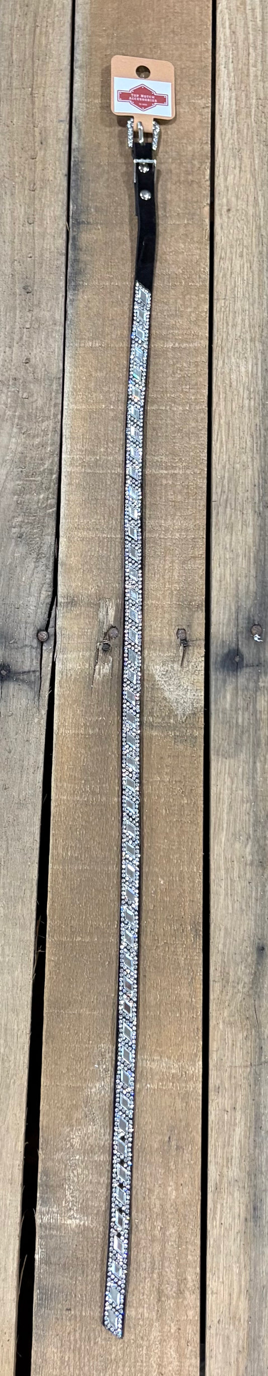 Long black hat band with clear and blue diamond sequence on a wooden surface