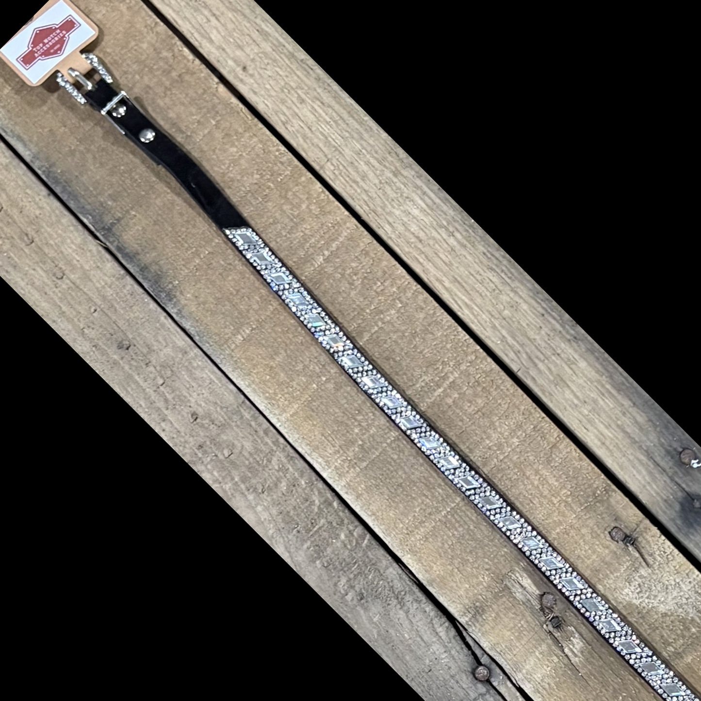 Long black hat band with clear diamond sequence on a wooden surface