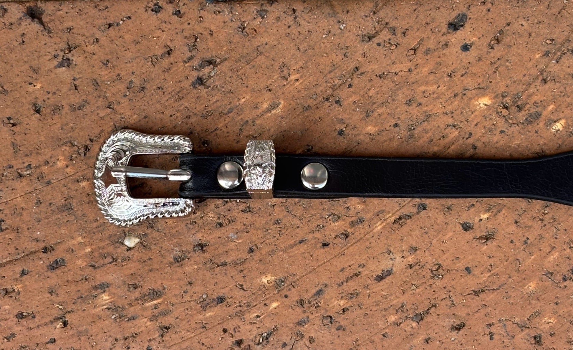 Black leather hat band with a Horse Head Concho with silver bands separating them. This hat band is fully adjustable with a Western style buckle. Close up of buckle. 