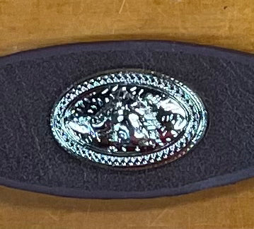 Silver Concho with Horse head figure on it. Coffee brown leather band on wooden background.