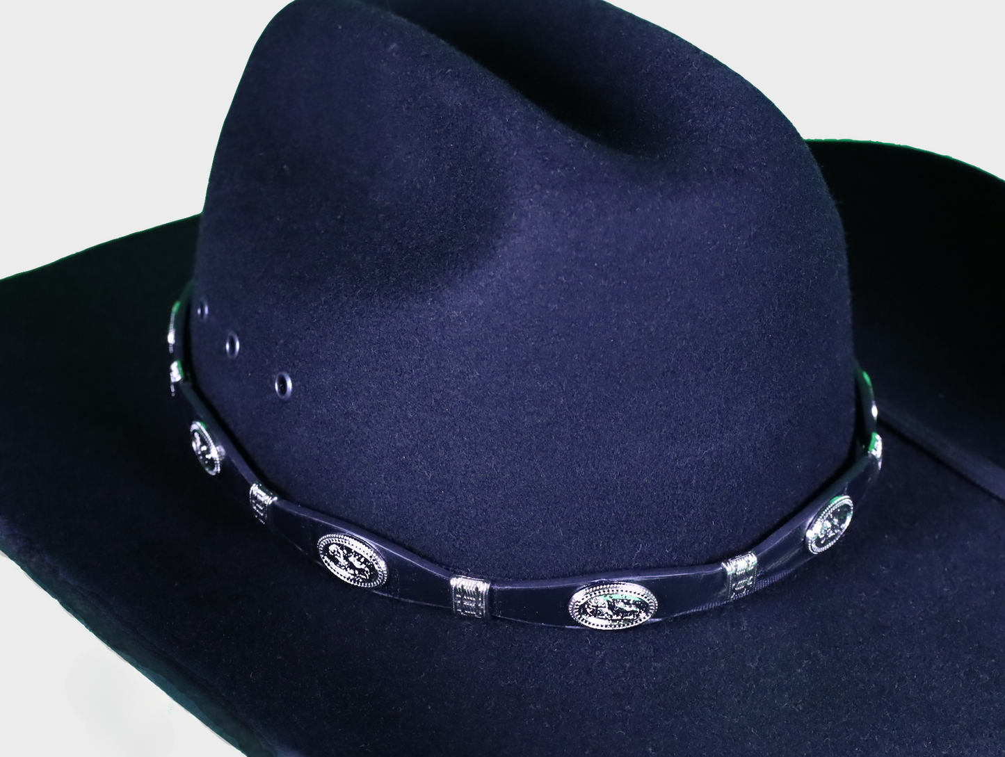 Black leather hat band with Praying Cowboy Conchos and a Western style buckle closure. Front View showing band on felt hat. 