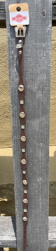 Decorative Coffee Brown leather hat band and silver buckle set and conchos on a wooden background