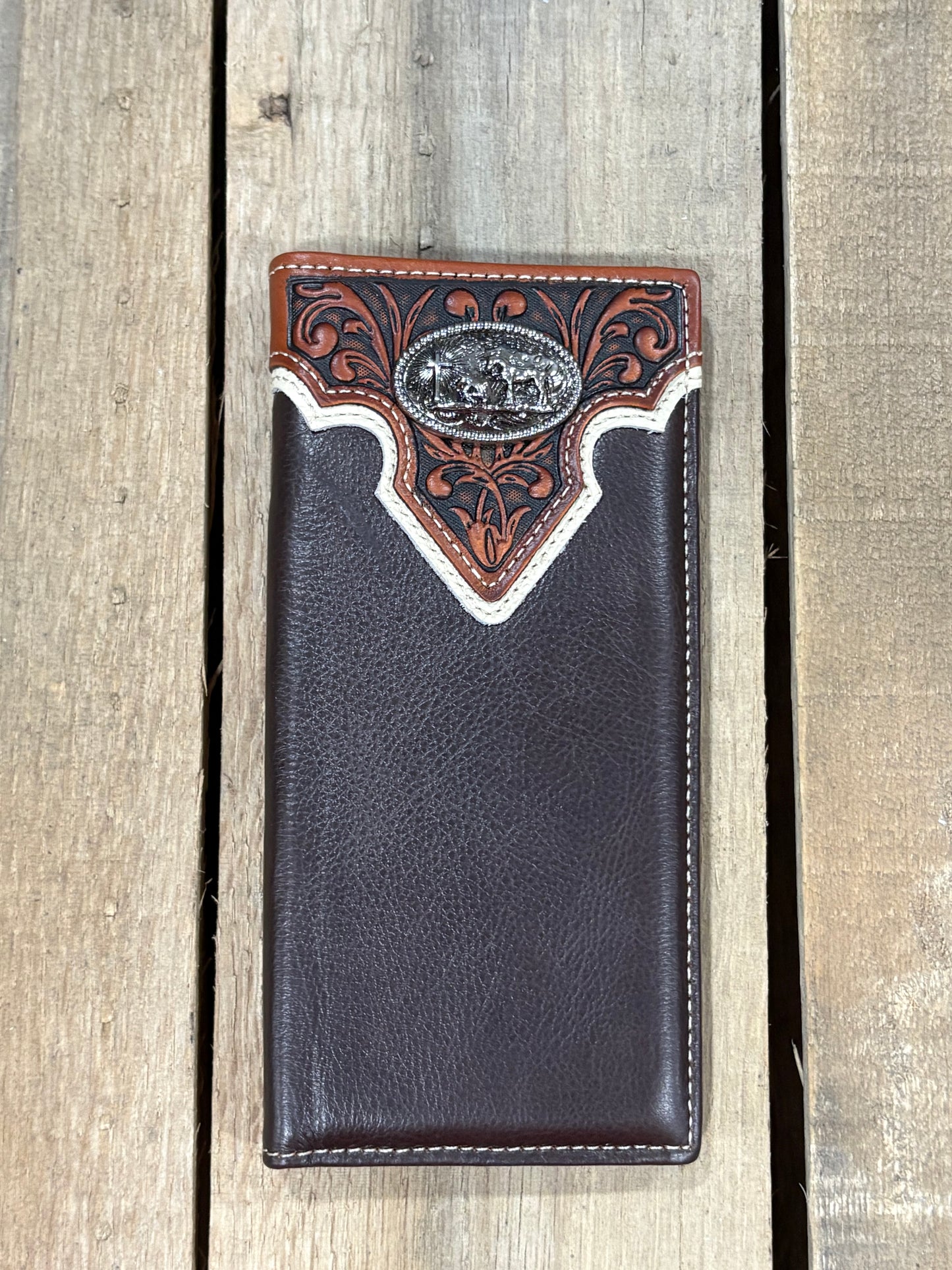 Coffee Brown leather wallet with decorative brown, white trim, and praying cowboy silver concho on a wooden surface