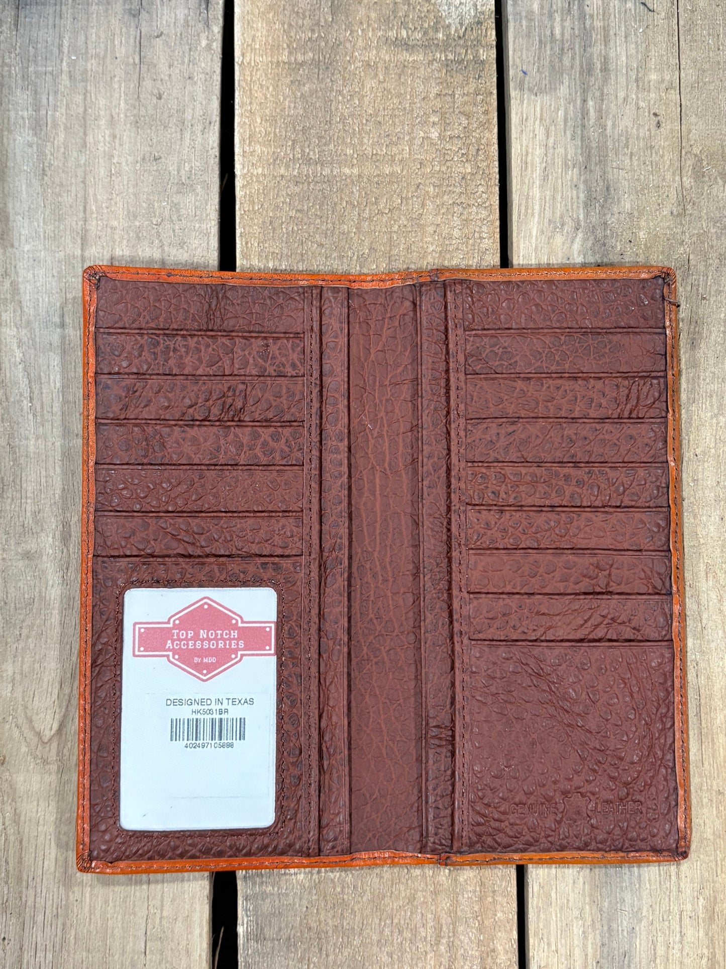 Brown leather wallet with a label on a wooden surface