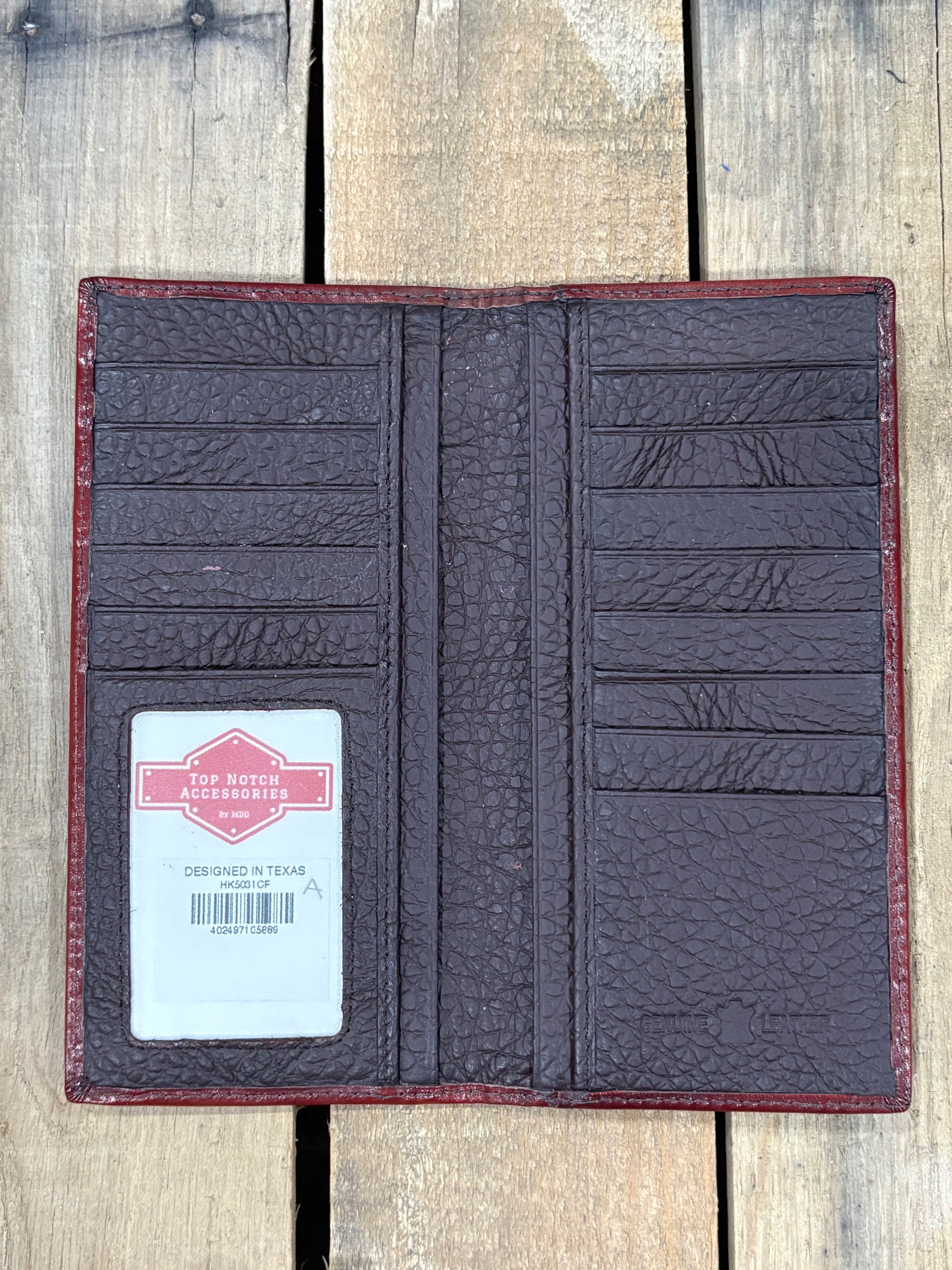 Open leather wallet on a wooden surface with a brand label visible