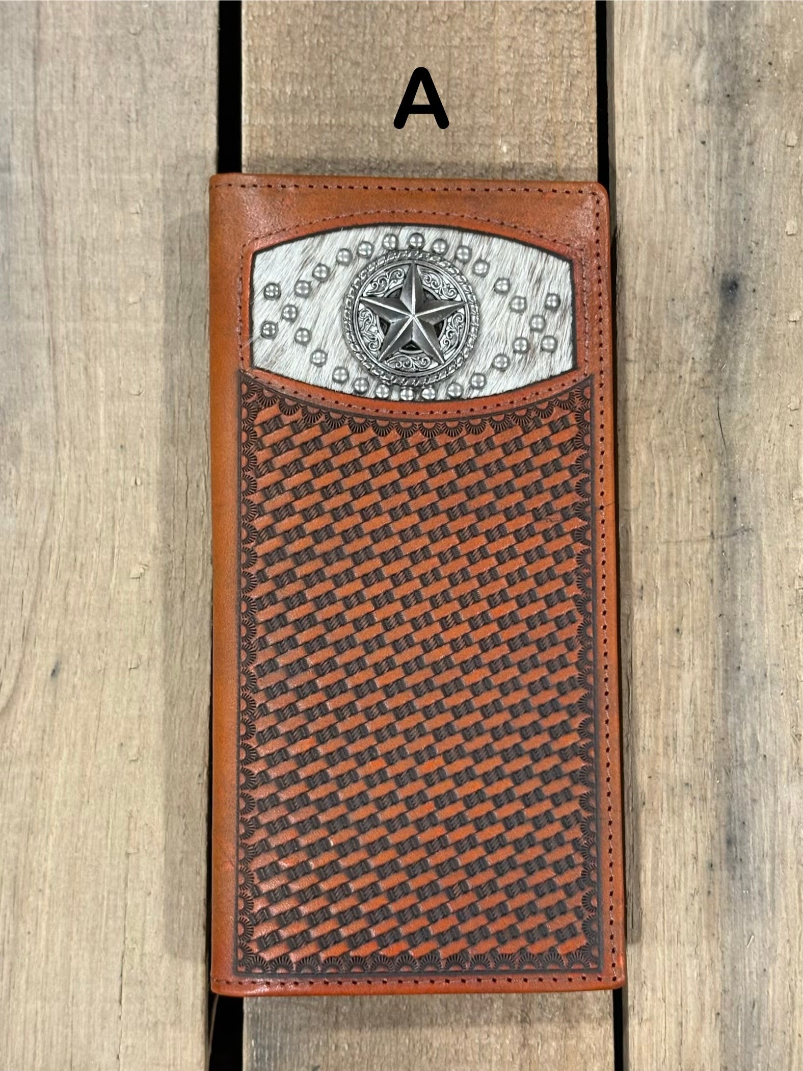 Brown leather wallet with star silver concho with embossed basketweave design on a wooden surface