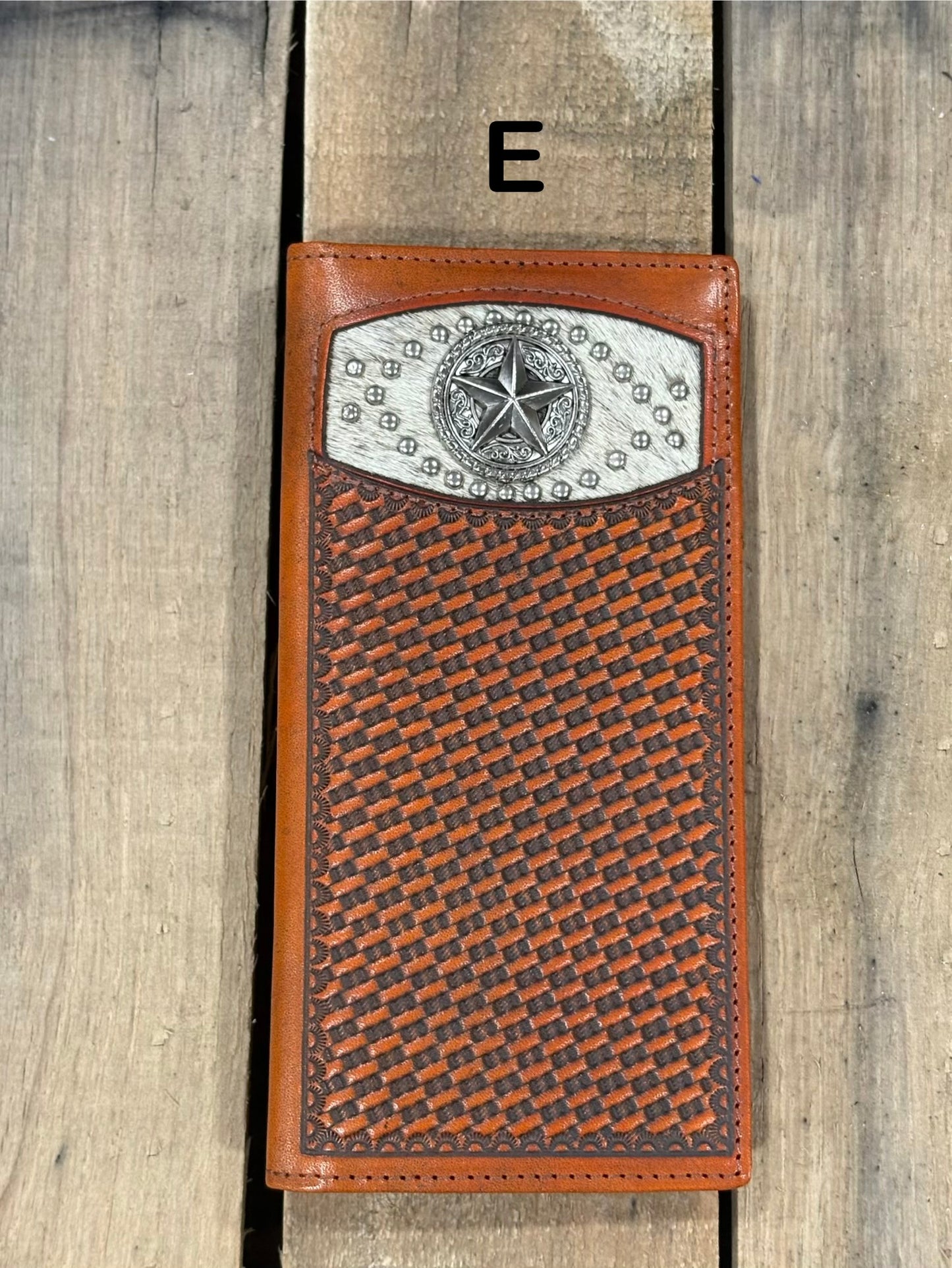 Brown leather wallet with star silver concho with embossed basketweave design on a wooden surface