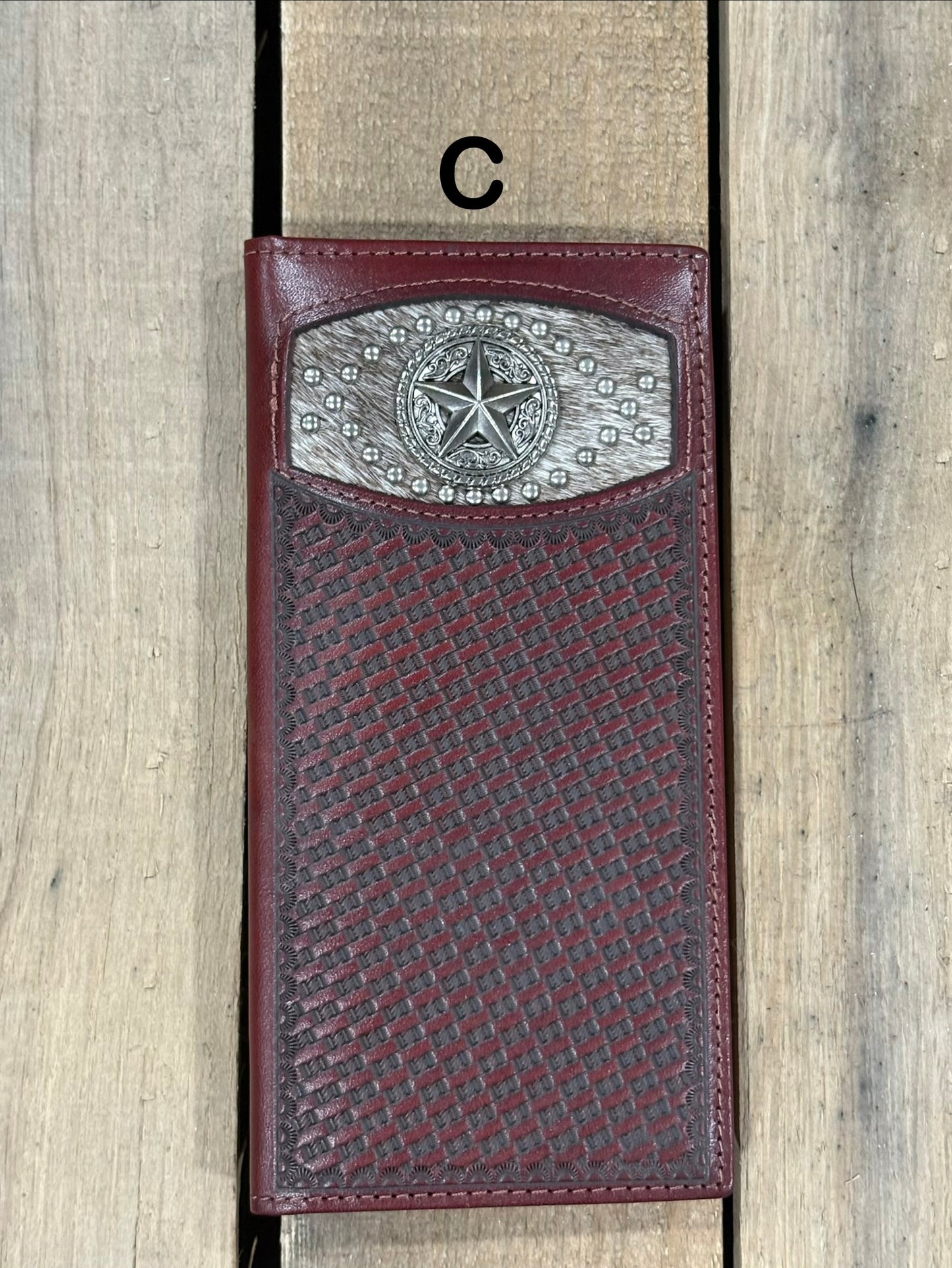 Coffee Brown leather wallet with star silver concho with embossed basketweave design on a wooden surface