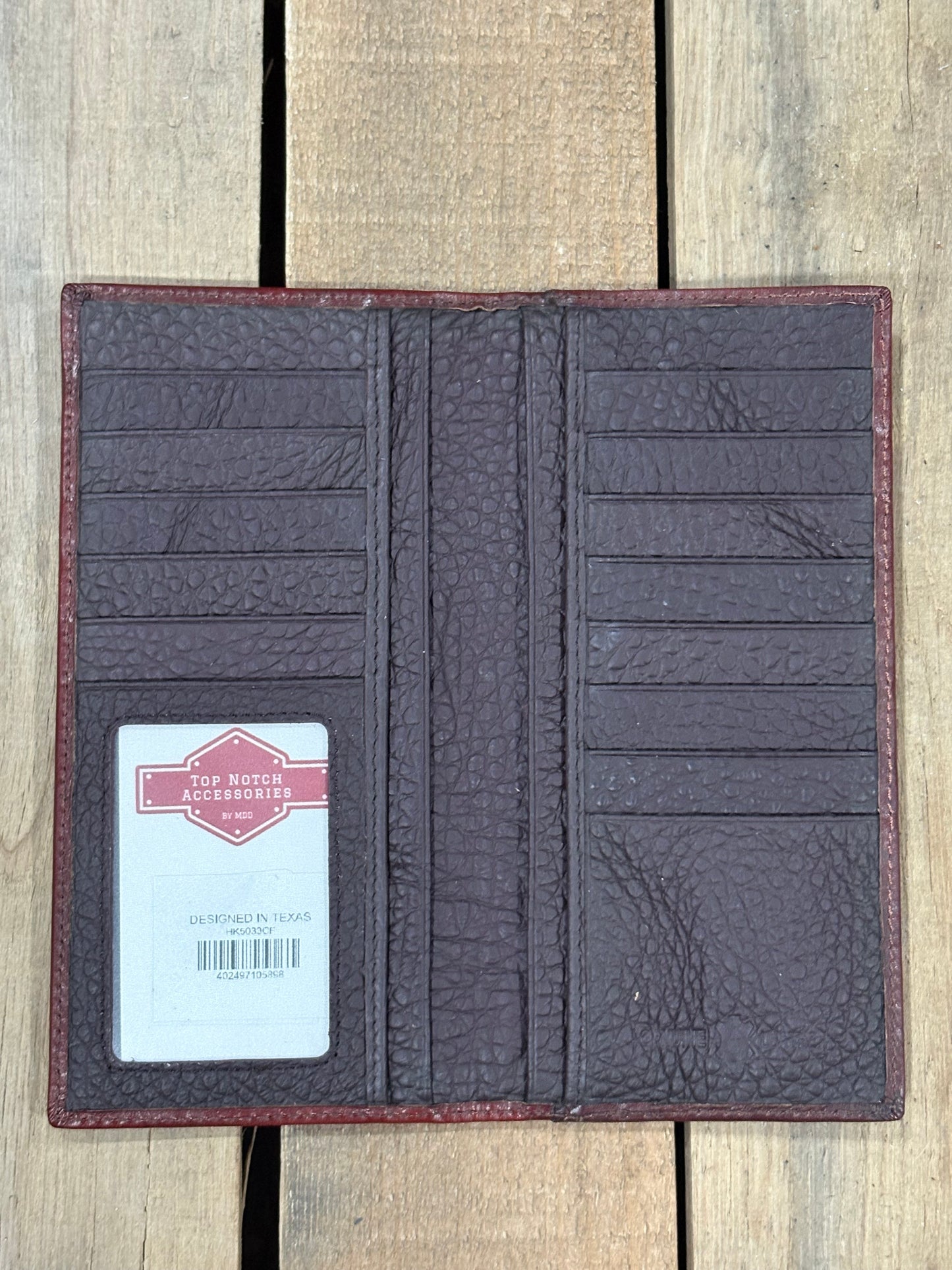Brown textured wallet with a card on a wooden surface