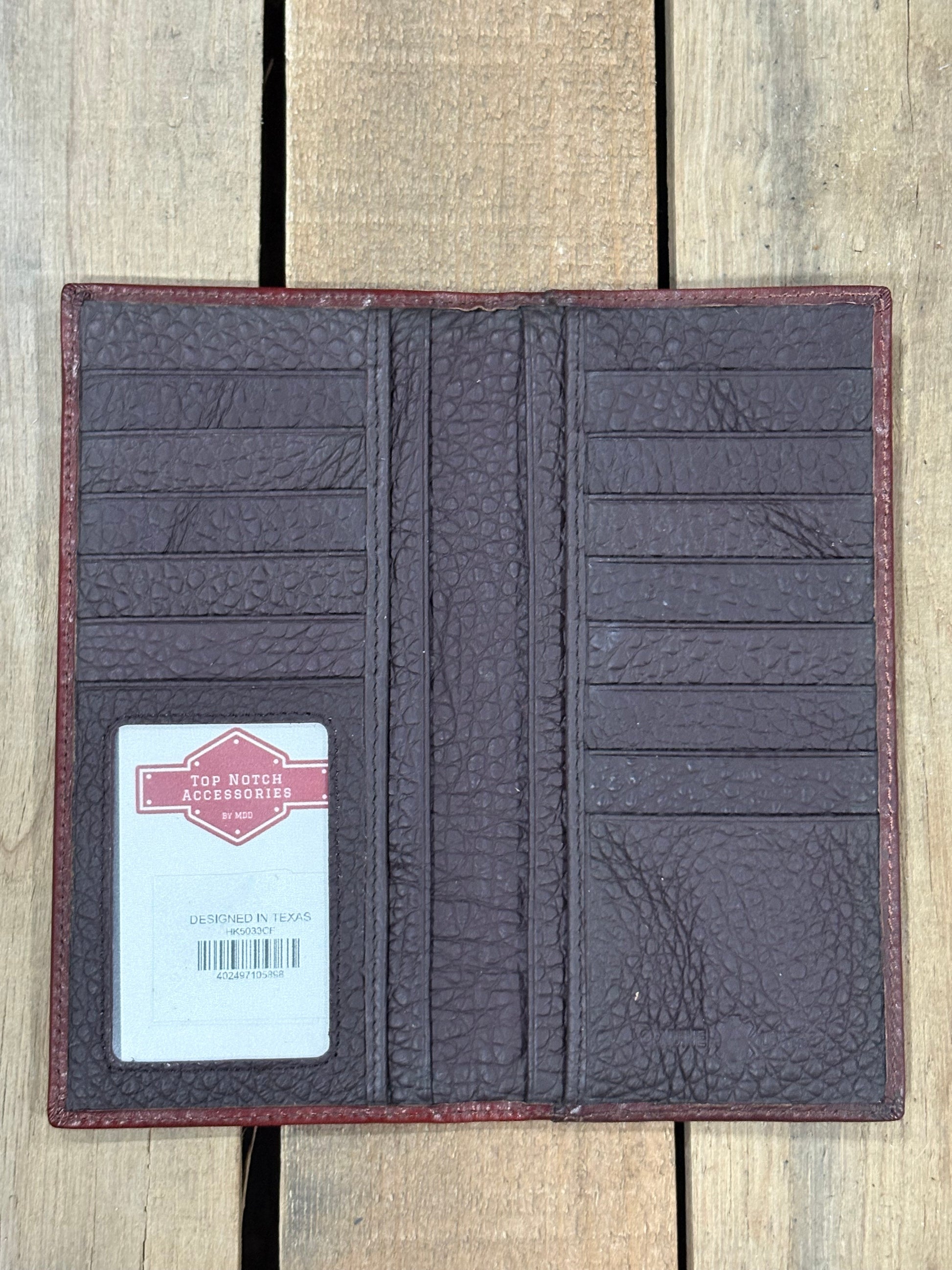Brown textured wallet with a card on a wooden surface