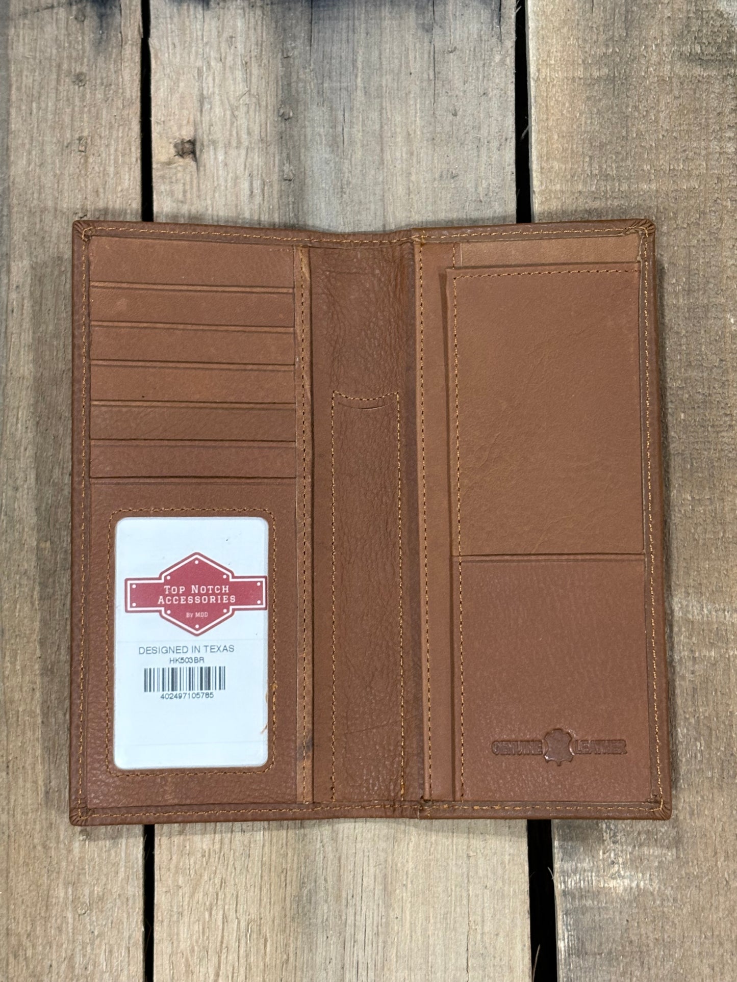 Brown leather wallet with a brand label on a wooden surface