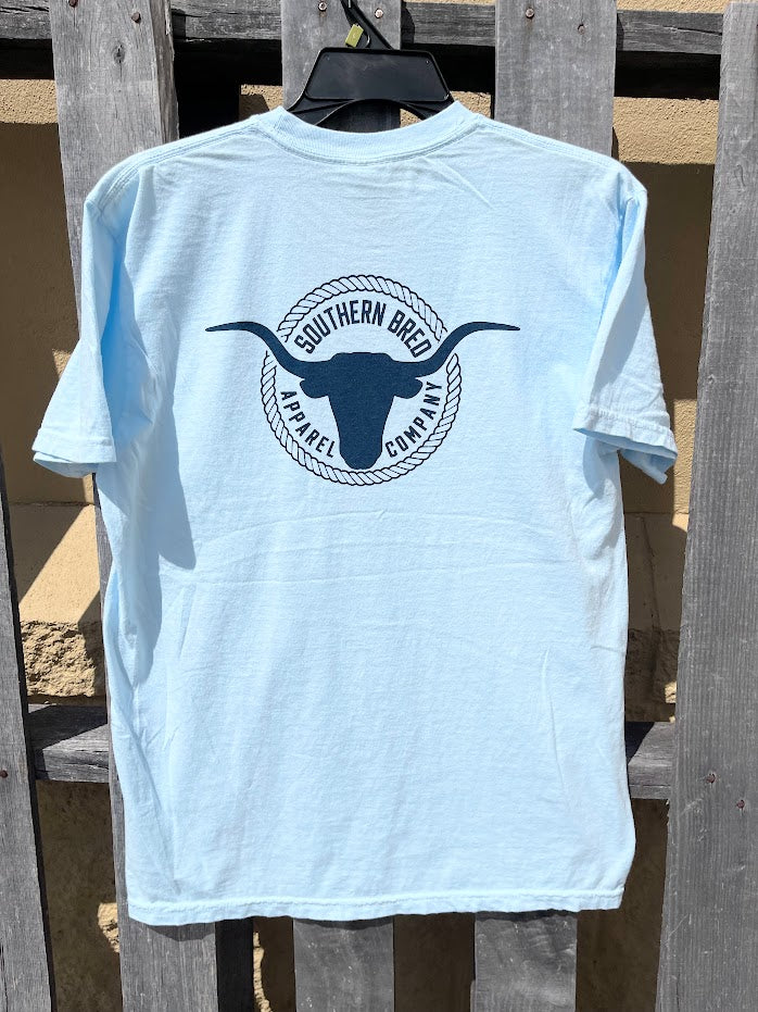 Light blue t-shirt with a Navy logo on a wooden background