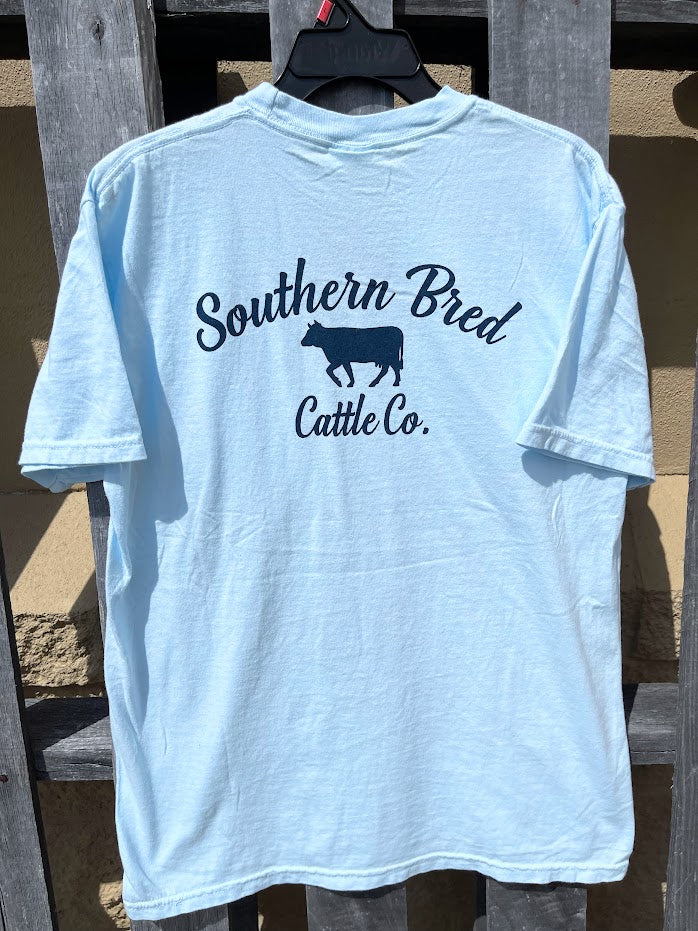 Light blue t-shirt with 'Southern Bred Cattle Co.' Navy text and cow silhouette on a wooden background