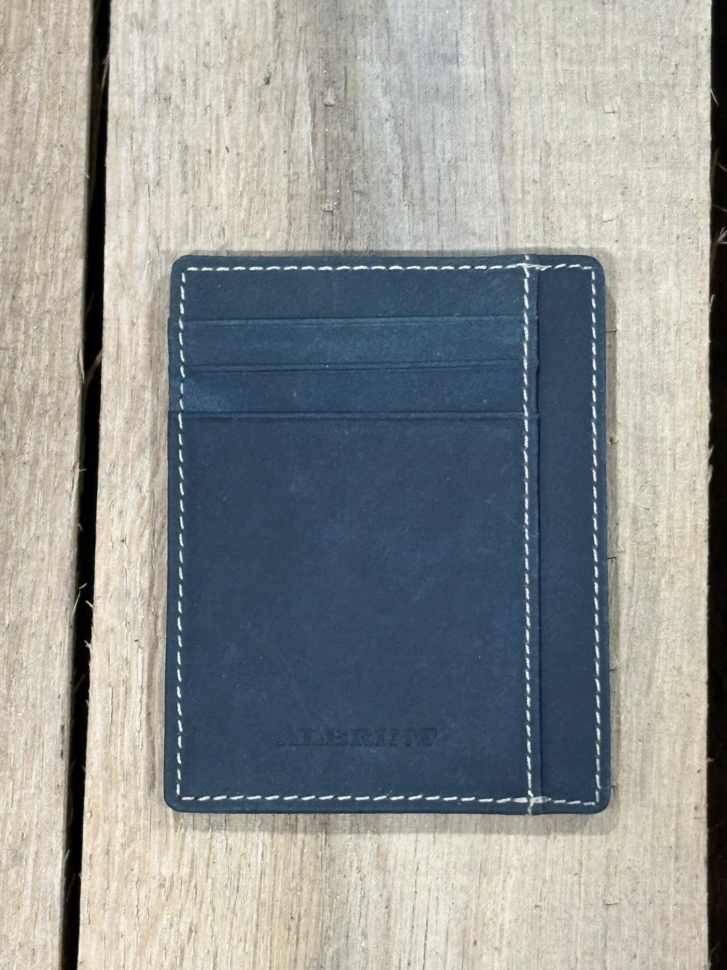 Black leather cardholder with white stitching on a wooden surface