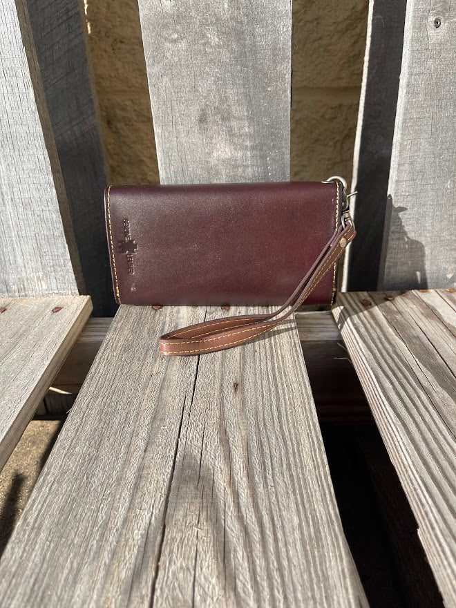 Coffee Brown leather phone case wallet with turquoise inlay and a wristlet strap.  Rear View 