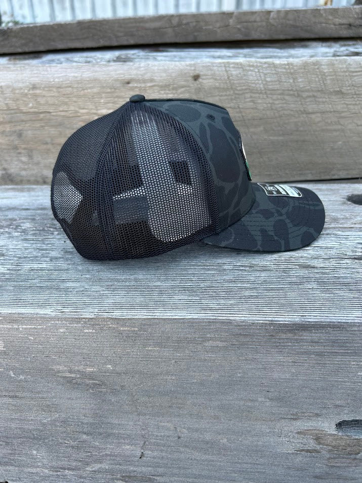 Black camouflage baseball cap on a wooden surface
