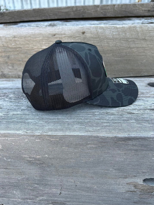 Black camouflage baseball cap on a wooden surface
