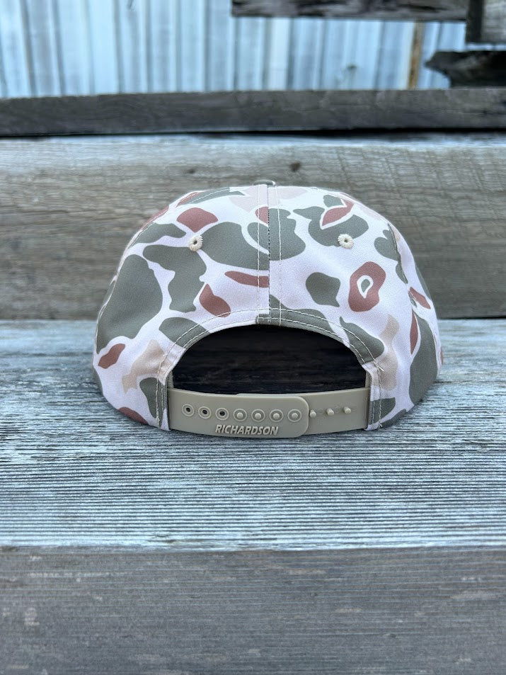 Camouflage-patterned cap on a wooden surface