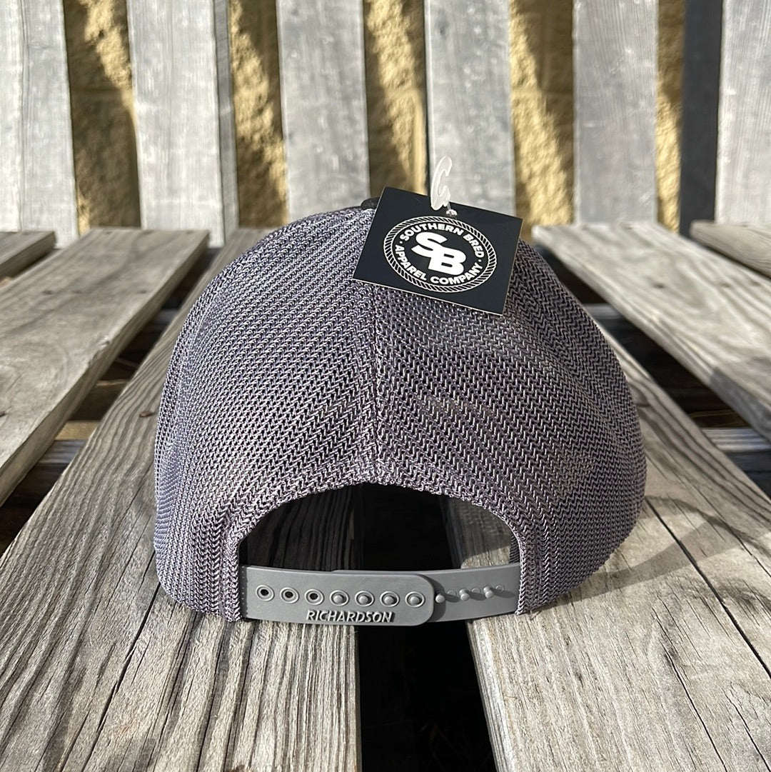 Gray mesh cap with a brand tag on a wooden surface