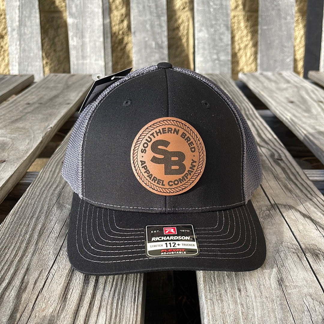 Black and gray cap with leather patch on a wooden surface