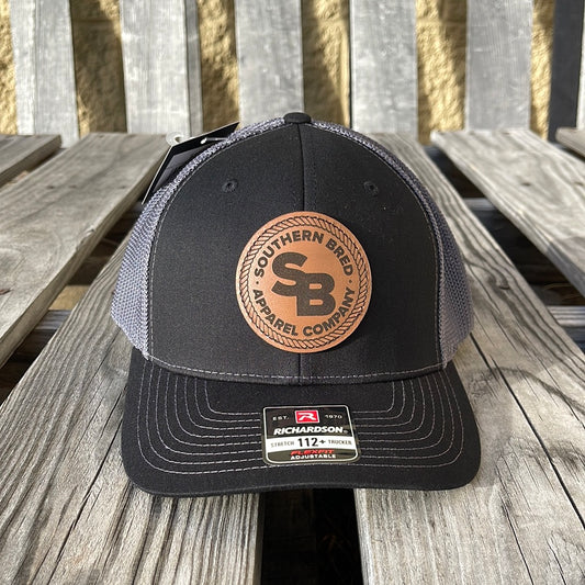 Black and gray cap with leather patch on a wooden surface