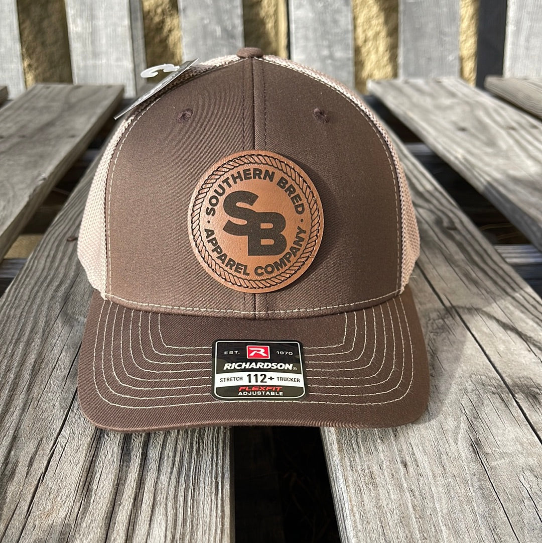Brown and beige cap with a logo on a wooden surface