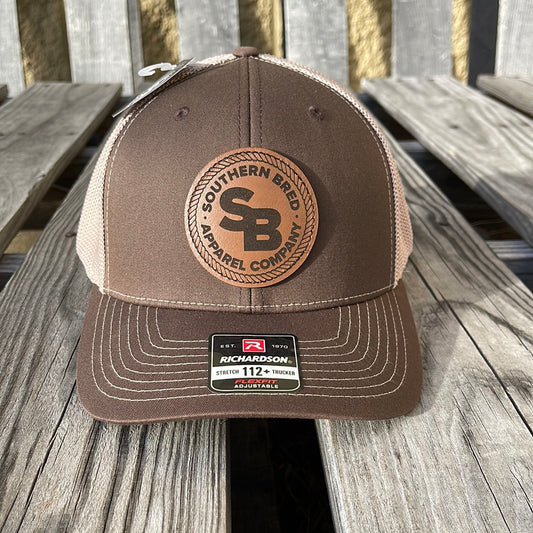 Brown and beige cap with a logo on a wooden surface