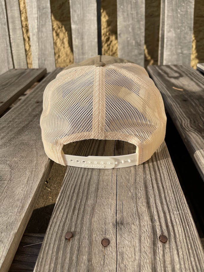 Beige mesh cap on a wooden surface