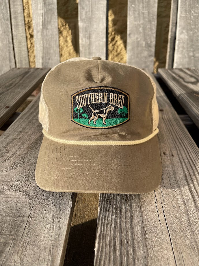 Loden green cap with embroidered logo on a wooden surface