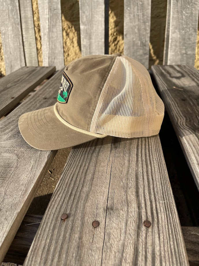 Loden green cap with a patch on a wooden surface