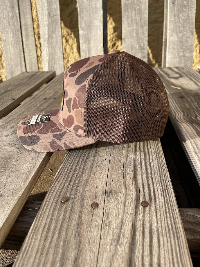 Brown camouflage cap on a wooden surface